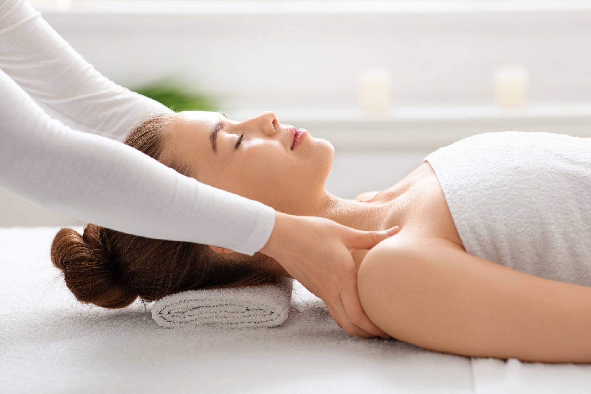 Side view of peaceful young lady having healing body massage Side view of peaceful young lady having healing body massage