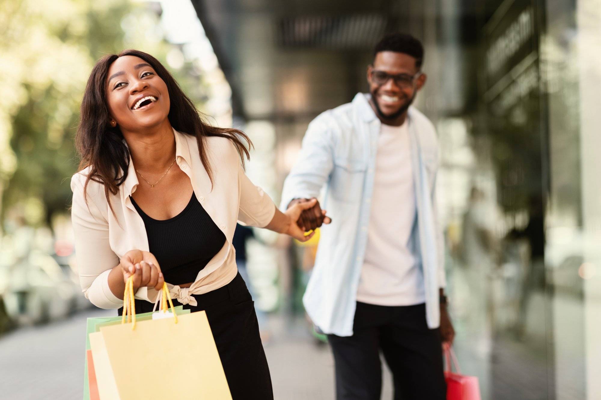 Excited Black Woman Pulling Boyfriend To Shopping Store Excited Black Woman Pulling Boyfriend To Shopping Store