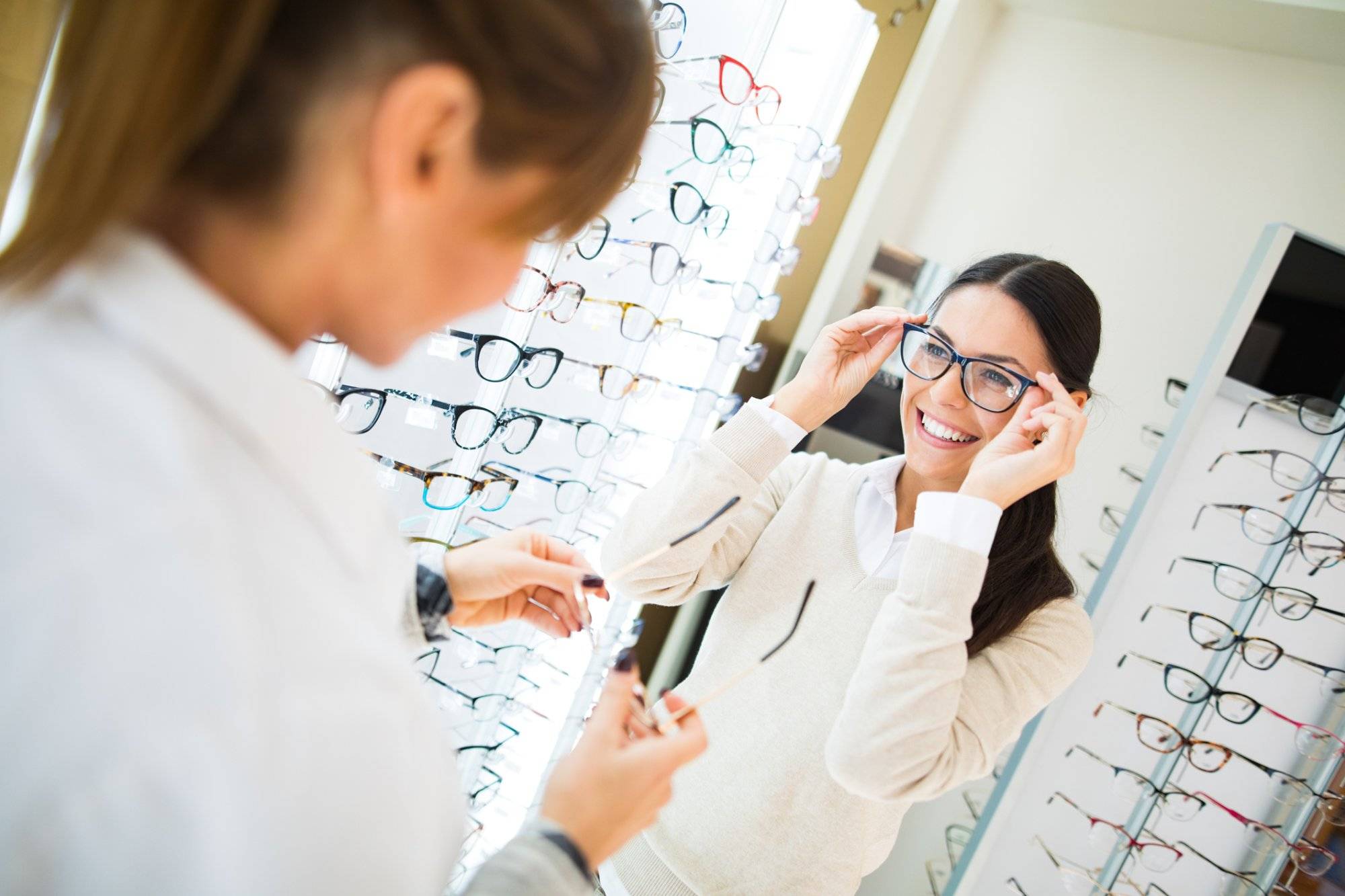 Woman trying on eyeglasses in optical shop Woman trying on eyeglasses in optical shop