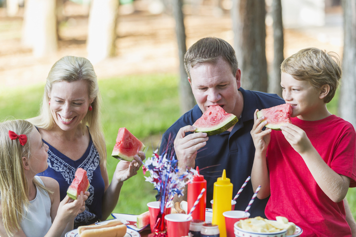 Family at fourth of July cookout eating watermelon