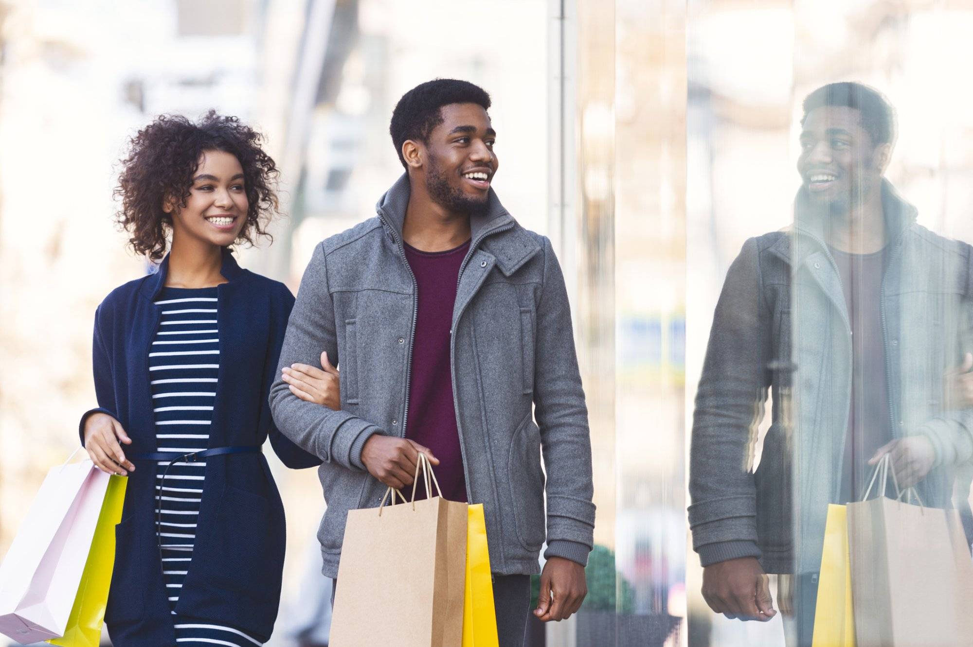 Cheerful black lovers walking down the street Cheerful black lovers walking down the street