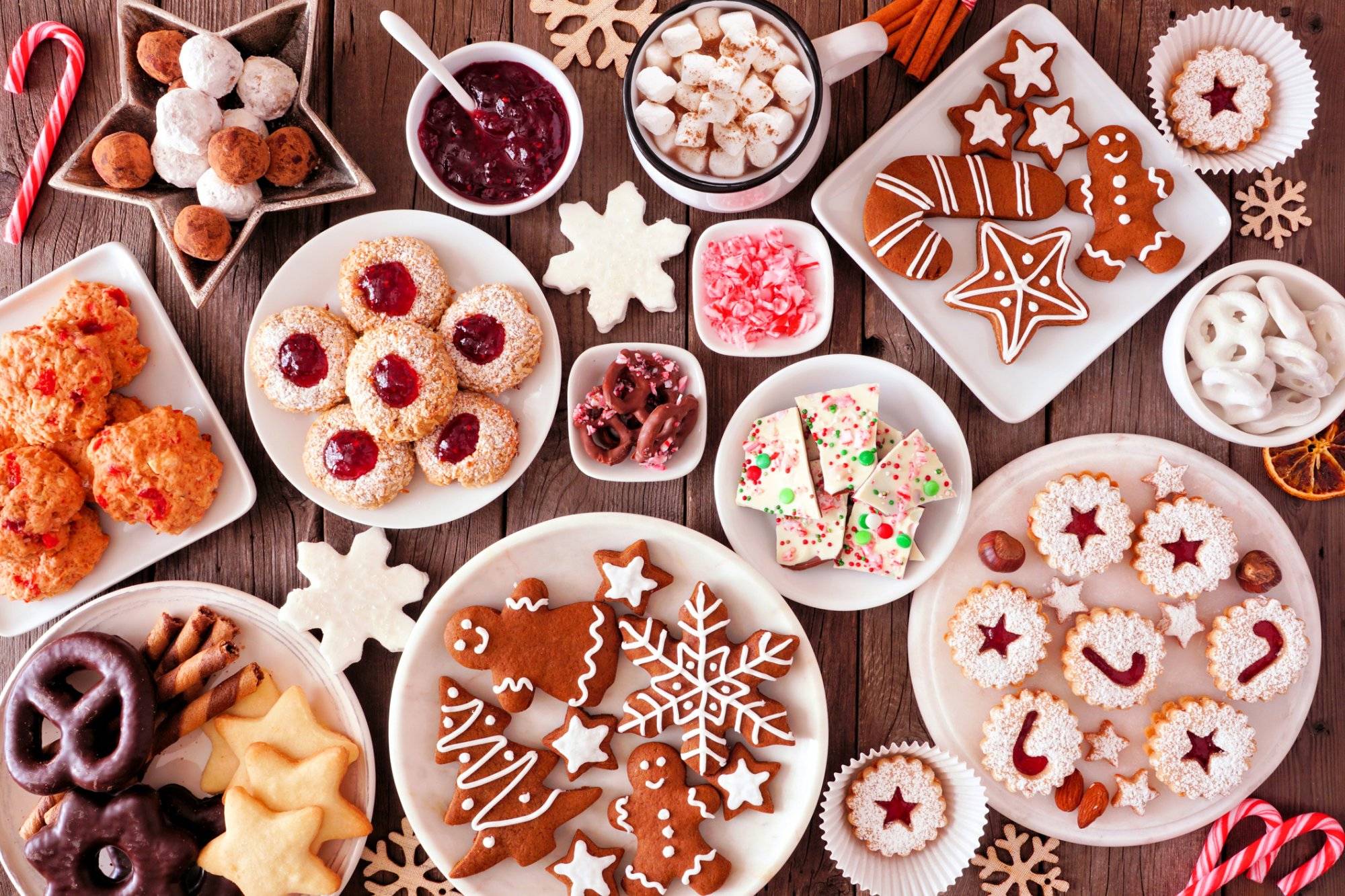 Christmas baking table scene with assorted sweets and cookies, top view over a rustic wood background Christmas table scene of assorted sweets and cookies. Top view over a rustic wood background. Holiday baking concept.
