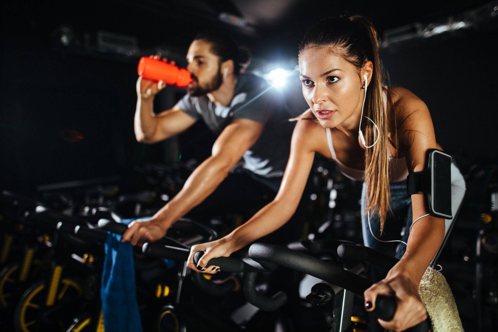 Two young people exercising on exercise bike at gym