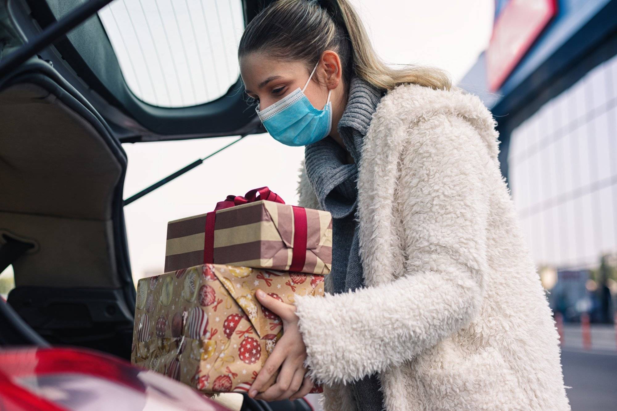 Teenage girl wears a protective mask while shopping for Christmas during COVID-19 pandemic