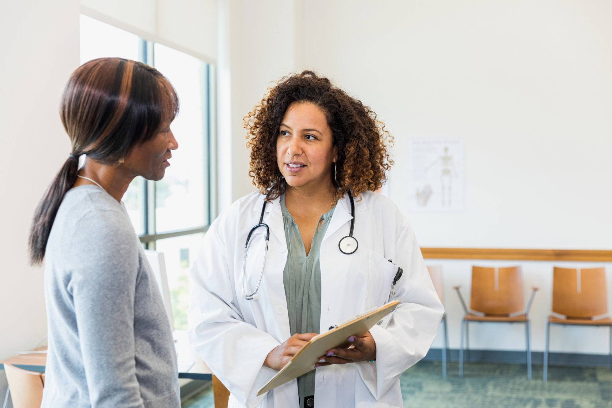 Senior female patient and mid adult doctor discuss test results