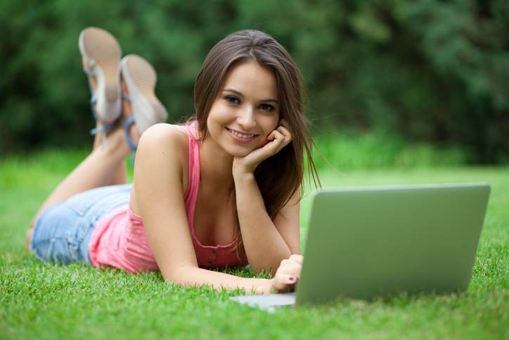 Young woman using laptop in park